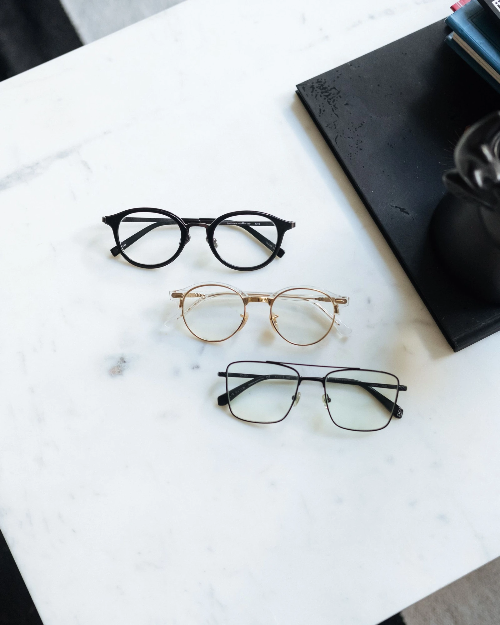 Three pairs of eyeglasses on a light tabletop